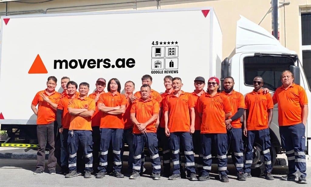 The movers.ae crew in branded uniforms standing in front of a company truck in Dubai